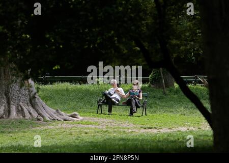 Bukarest, Rumänien. Mai 2021. Menschen lesen in einem Park in Bukarest, Rumänien, 15. Mai 2021. Der rumänische Premierminister Florin Citu sagte, die Regierung habe am Freitag eine Entscheidung getroffen, die Einschränkungen im Zusammenhang mit dem Coronavirus ab Samstag schrittweise zu lockern. Ab Samstag wird die Sperrstunde in der Nacht aufgehoben, und die obligatorischen Maskenregeln werden nur in geschlossenen öffentlichen Räumen und überfüllten öffentlichen Bereichen, einschließlich Märkten, öffentlichen Verkehrsmitteln und Arbeitsplätzen, angewendet. Quelle: Cristian Cristel/Xinhua/Alamy Live News Stockfoto