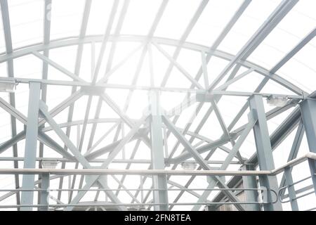 Die Sonne scheint durch die Gitterstrukturen des überdachten Fußgängers Überführung Stockfoto