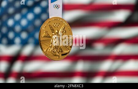 25. April 2021 Tokio, Japan. Goldmedaille der XXXII. Olympischen Sommerspiele 2020 in Tokio auf dem Hintergrund der US-Flagge. Stockfoto