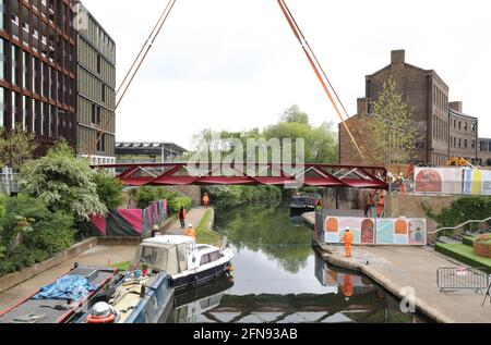 London, Großbritannien, 15. Mai 2021, Neue Fußgängerbrücke wird über den Regents Canal am Granary Square am Kings Cross installiert. Menschenmengen versammelten sich, um zuzusehen und jubelten über die Fertigstellung. Monica Wells/Alamy Live News Stockfoto