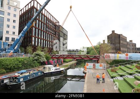 London, Großbritannien, 15. Mai 2021, Neue Fußgängerbrücke wird über den Regents Canal am Granary Square am Kings Cross installiert. Menschenmengen versammelten sich, um zuzusehen und jubelten über die Fertigstellung. Monica Wells/Alamy Live News Stockfoto