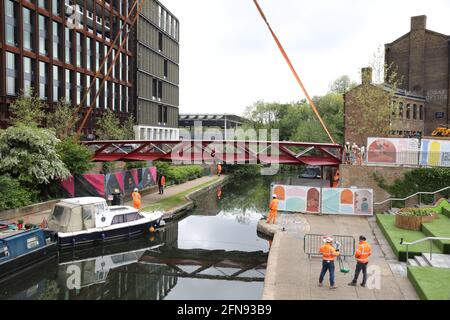 London, Großbritannien, 15. Mai 2021, Neue Fußgängerbrücke wird über den Regents Canal am Granary Square am Kings Cross installiert. Menschenmengen versammelten sich, um zuzusehen und jubelten über die Fertigstellung. Monica Wells/Alamy Live News Stockfoto