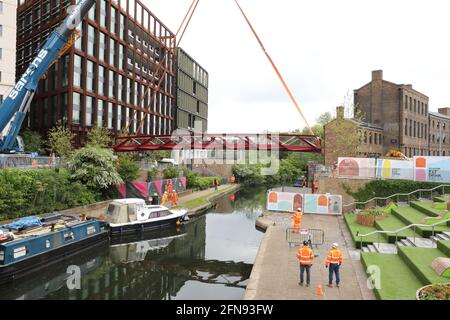 London, Großbritannien, 15. Mai 2021, Neue Fußgängerbrücke wird über den Regents Canal am Granary Square am Kings Cross installiert. Menschenmengen versammelten sich, um zuzusehen und jubelten über die Fertigstellung. Monica Wells/Alamy Live News Stockfoto