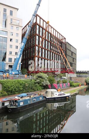 London, Großbritannien, 15. Mai 2021, Neue Fußgängerbrücke wird über den Regents Canal am Granary Square am Kings Cross installiert. Menschenmengen versammelten sich, um zuzusehen und jubelten über die Fertigstellung. Monica Wells/Alamy Live News Stockfoto
