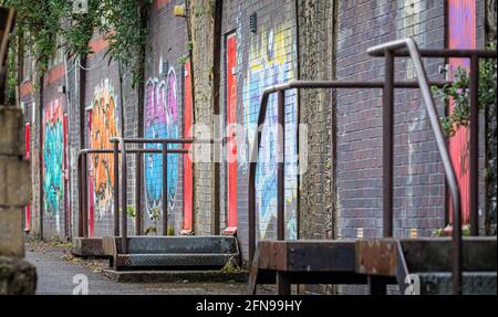 Bunte Graffiti auf einer Reihe von Ziegelbögen - Teil der alten Lagerhäuser in Bath, Somerset, Großbritannien, am 14. Mai 2021 Stockfoto