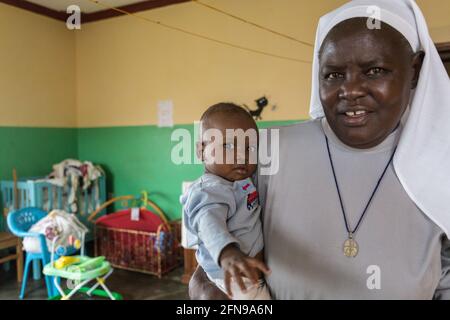 Porträt einer Nonne und eines Babys in St. Kizito Waisenhaus im ländlichen Osten Ugandas Stockfoto