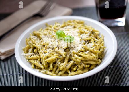 Pasta mit Pesto-Sauce und Parmesan auf einem Teller. Stockfoto