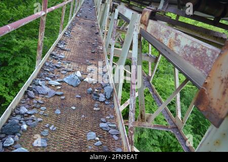 Brücke mit Förderband, die Eisenerz zur Fabrik transportiert Verbindung mit der Mine im Berg Stockfoto