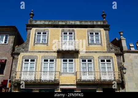 Obere 2 Etagen des Gebäudes mit Fassade aus gelben Keramikfliesen auf dem Hauptplatz von Praça Conselheiro Silva Torres, Caminha, Provinz Minho, Portugal Stockfoto