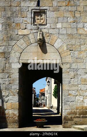 Blick entlang der Rua Direita durch den Torbogen des Uhrturms / Torre do Relógio, Caminha, Provinz Minho, Portugal Stockfoto