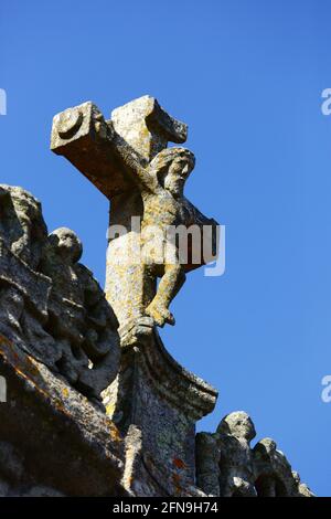 Detail eines geschnitzten Kruzifixes aus Stein über dem Seiteneingang der gotischen / Renaissance Pfarrkirche / Igreja Matriz, Caminha, Minho Provinz, Portugal Stockfoto