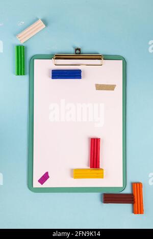 Flaches blaues Klemmbrett mit Plastilin auf blauem Hintergrund. Frame-Mockup mit Kopierplatz für Text. Tetris-Spiel Stockfoto