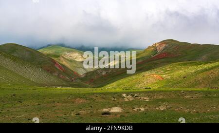 Dicke Wolken über grünen Bergen Stockfoto