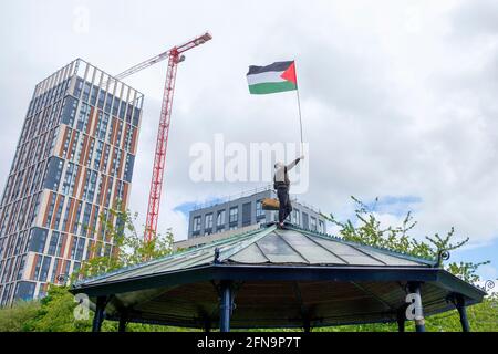 Bristol, Großbritannien. Mai 2021. Ein pro-palästinensischer Protestler wird mit einer palästinensischen Flagge auf einem Bandstand im Castle Park abgebildet, während pro-palästinensische Unterstützer nach einem pro-palästinensischen protestmarsch durch Bristol Reden hören. Der protestmarsch und die Kundgebung wurden abgehalten, um den Menschen zu ermöglichen, ihre Unterstützung und Solidarität mit dem palästinensischen Volk nach 73 Jahren Nakba zu zeigen und gegen Israels jüngste Aktionen in Gaza zu protestieren. Quelle: Lynchpics/Alamy Live News Stockfoto