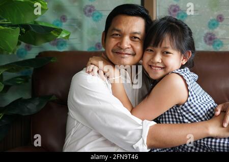 Liebenswert asiatische Tochter umarmt liebevollen Vater mit Liebe und Zärtlichkeit.Konzept Des Vatertages Stockfoto