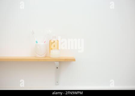 Ein Holzregal an der Wand mit Zahnbürste, Suppe und Shapmpoo im Badezimmer zu Hause oder im Hotel. Stockfoto