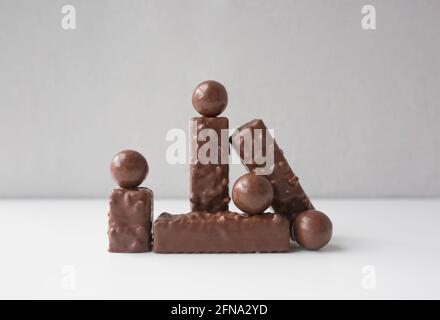 Schokoladenwaffeln und Süßigkeiten auf weißem Tisch an der Wand. Stockfoto