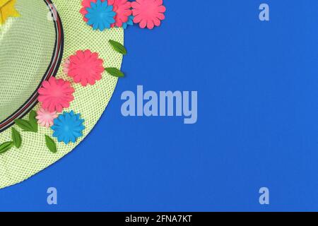 Sommer Strohhut flach Lay Komposition mit Papierblumen auf einem blauen Hintergrund, Draufsicht und Kopierraum Stockfoto