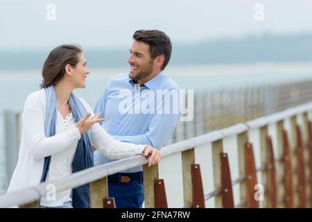 Ein Paar mittleren Alters plaudert auf der Brücke Stockfoto