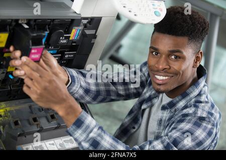 Ein Mann bedient einen Kopierer Stockfoto