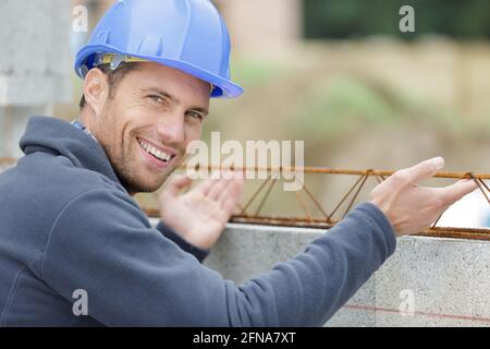 Glücklicher Mann neben der Konstruktion Stahlbetonkonstruktion Stockfoto
