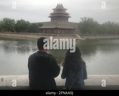 Peking, China. Mai 2021. Ein chinesisches Paar blickt am Samstag, den 15. Mai 2021, unter einem verschmutzten Himmel in Peking auf einen Teil der Verbotenen Stadt. Die zunehmende Luftverschmutzung in der Hauptstadt hat laut einer neuen akademischen Studie Befürchtungen aufkommen lassen, dass Athleten bei den Olympischen Winterspielen 2022 im Februar unter gefährlicher, verschmutzter Luft konkurrieren könnten. Foto von Stephen Shaver/UPI Credit: UPI/Alamy Live News Stockfoto