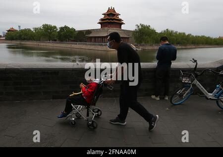 Peking, China. Mai 2021. Ein Chinese schiebt seinen Sohn am Samstag, den 15. Mai 2021, unter einem verschmutzten Himmel in Peking an einem Teil der Verbotenen Stadt vorbei. Die zunehmende Luftverschmutzung in der Hauptstadt hat laut einer neuen akademischen Studie Befürchtungen aufkommen lassen, dass Athleten bei den Olympischen Winterspielen 2022 im Februar unter gefährlicher, verschmutzter Luft konkurrieren könnten. Foto von Stephen Shaver/UPI Credit: UPI/Alamy Live News Stockfoto