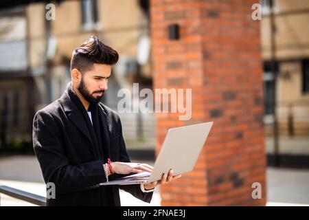 East Indian American College Student auf dem Campus, arbeitet auf Laptop-Computer. Stockfoto