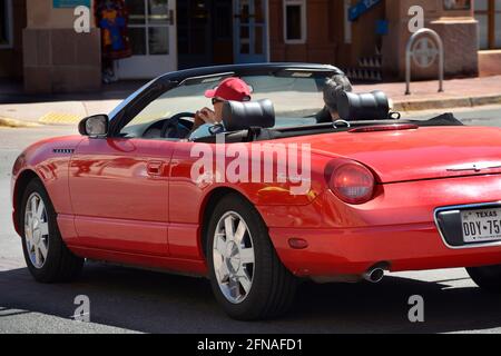 Ein älteres Paar, das aus Texas nach Santa Fe, New Mexico, reist, genießt die Besichtigung in ihrem roten Thunderbird Cabrio. Stockfoto