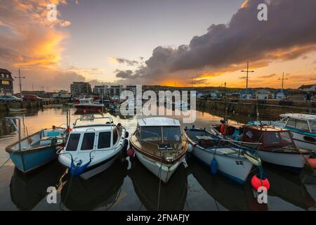 West Bay, Dorset, Großbritannien. Mai 2021. Wetter in Großbritannien. Blick auf den Hafen von West Bay in Dorset, wenn der Himmel nach einem Tag voller heftiger Regenschauer bei Sonnenuntergang klar wird. Bildnachweis: Graham Hunt/Alamy Live News Stockfoto