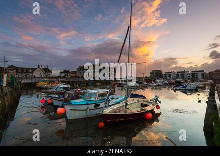 West Bay, Dorset, Großbritannien. Mai 2021. Wetter in Großbritannien. Blick auf den Hafen von West Bay in Dorset, wenn der Himmel nach einem Tag voller heftiger Regenschauer bei Sonnenuntergang klar wird. Bildnachweis: Graham Hunt/Alamy Live News Stockfoto