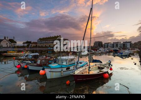 West Bay, Dorset, Großbritannien. Mai 2021. Wetter in Großbritannien. Blick auf den Hafen von West Bay in Dorset, wenn der Himmel nach einem Tag voller heftiger Regenschauer bei Sonnenuntergang klar wird. Bildnachweis: Graham Hunt/Alamy Live News Stockfoto