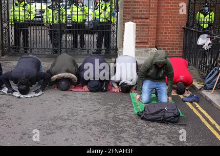 London, Großbritannien. Mai 2021. Muslimische Demonstranten, die an einer Anti-Israel-Demonstration in London teilnehmen, nehmen sich einen Moment Zeit, um vor Toren in der Nähe des Kensington Palace zu beten. Quelle: Joe Kuis /Alamy News Stockfoto