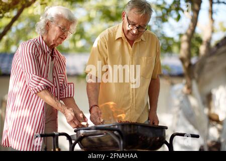 Älteres kaukasisches Paar, das Grill macht Stockfoto