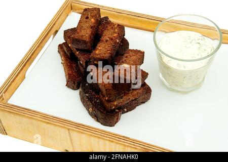 Brotsnack mit schwarzem Knoblauch. Gebratene Knoblauchkröten auf weißem Betontisch. Isolieren auf weißem Hintergrund. Stockfoto