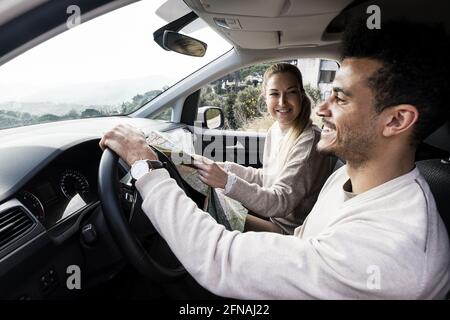 Glückliches junges Paar in einem Auto, das in den Urlaub fährt Stockfoto