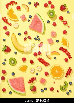 Verschiedene frische Früchte und Beeren auf gelbem Hintergrund, Draufsicht Stockfoto