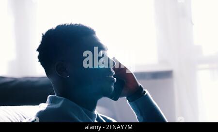 Nahaufnahme eines afroamerikanischen Mannes, der mit jemandem auf seinem Handy spricht. Hochwertige Fotos Stockfoto