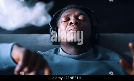 Afroamerikanischer Mann, der Kopfhörer trägt und Musik hört. Konzept der Ruhe und Entspannung. Hochwertige Fotos Stockfoto