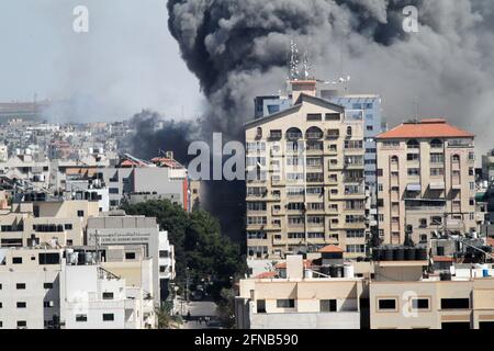 Gaza City, Gaza City. Mai 2021. Rauch wehte nach einem israelischen Luftangriff auf den Jala Tower, der am 15. Mai 2021 Büros von Al-Jazeera TV und Associated Press sowie Wohnwohnungen in Gaza City beherbergte. Israel sagte am Samstag, dass es das Hochhaus in Gaza-Stadt, in dem internationale Medien untergebracht sind, getroffen habe, weil es Vermögenswerte des Hamas-Geheimdienstes enthielt. Kredit: Rizek Abdeljawad/Xinhua/Alamy Live Nachrichten Stockfoto