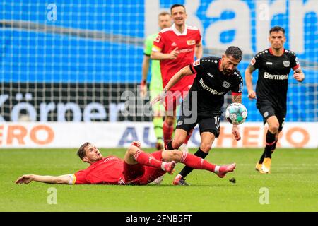 Leverkusen. Mai 2021. Kerem Demirbay (2. R) aus Leverkusen steht mit Christopher Lenz (1. L) von Union Berlin während eines Bundesliga-Spiels zwischen Bayer 04 Leverkusen und dem FC Union Berlin am 15. Mai 2021 in Leverkusen vor. Quelle: Xinhua/Alamy Live News Stockfoto