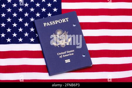 Stornierte US-Passbuch auf der Flagge der Vereinigten Staaten von Amerika. Der Pass wird durch Stanzen von zwei Löchern in der Abdeckung - San Jose, Califo, annulliert Stockfoto