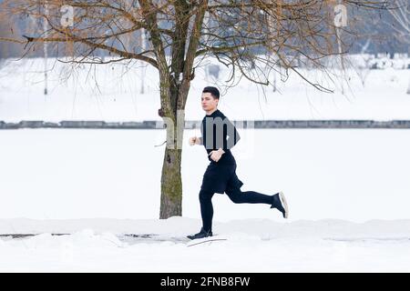 Der junge Mann geht im Winter beim Sport joggen. Stockfoto