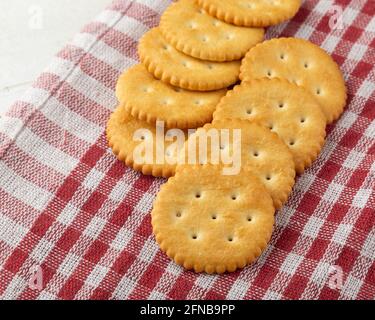 Cracker Kekse mit Tischdecke auf weißem Holztisch Hintergrund. Stockfoto