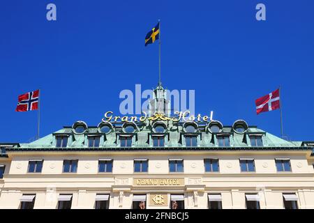 Stockholm, Schweden - 12. Mai 2021: Blick auf die Fassade des Grand Hotels Stockholm mit Flaggen von Norwegen, Schweden und Dänemark. Stockfoto