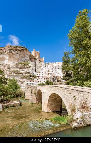 Alcala del Jucar, Spanien. Malerische und touristische weiße Stadt in einem Fluss Jucar Mäander mit einer Steinbrücke. Stockfoto