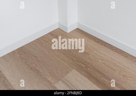 Holzfußboden mit weißer Wand Stockfoto
