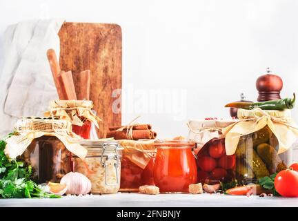 Fermentierte, eingelegte, marinierte vegetarische Speisen. Sommer Bio-Gemüse und Obst in Gläsern mit Gewürzen und Kräutern auf weißer Küche Stockfoto