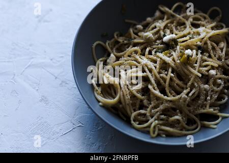 Ein Teller mit Spaghetti-Pasta auf blauem Hintergrund. Stockfoto