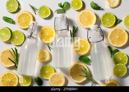 Drei Glasflaschen Limonade auf tropischem Hintergrund Stockfoto